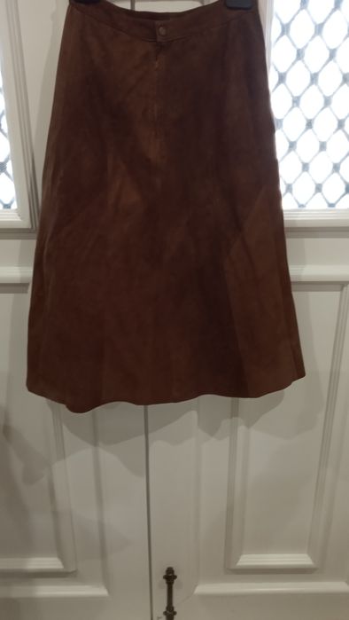 Saia castanha, comprida, em pele natural e macia.