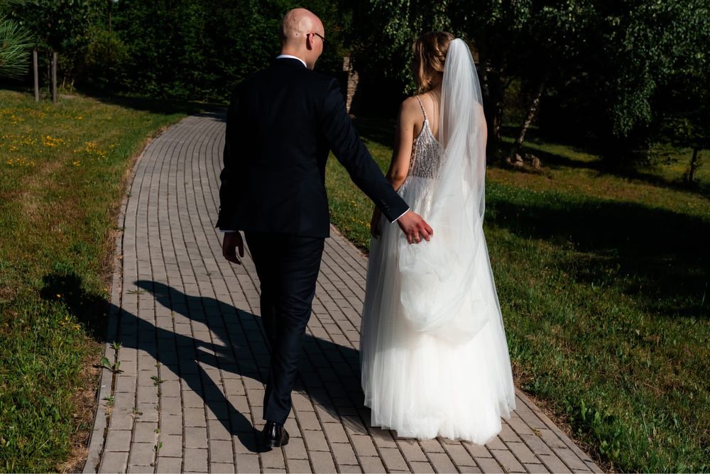 Suknia ślubna ze zdobionym gorsetem i lejącym tiulem