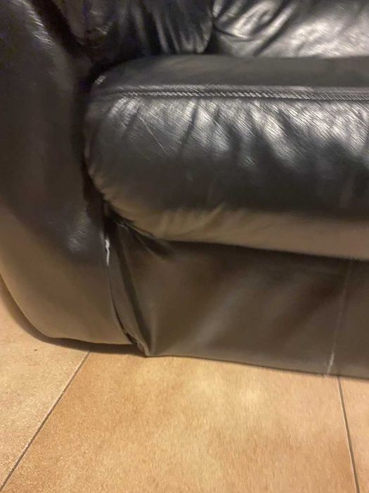 Sofá preto de dois lugares, usado.