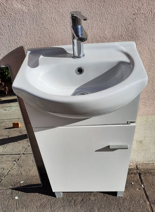 Pequeno móvel com lavatório, torneira e espelho