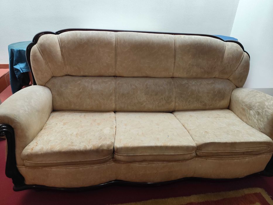 Sofá com estrutura em madeira e estofos em tecido bege com padrão discreto