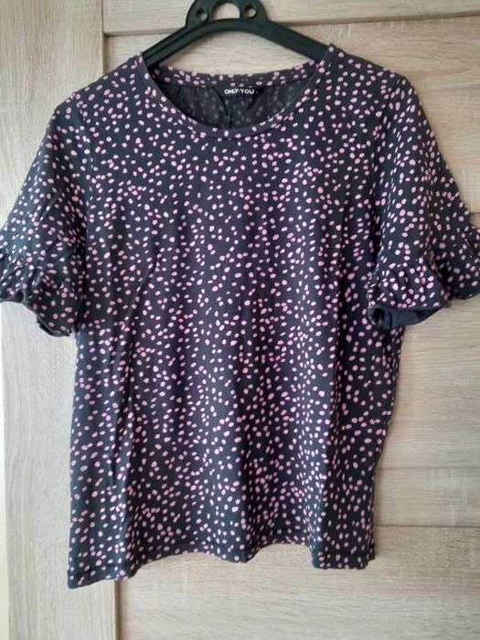 Czarna bluzka w różowe kropki.