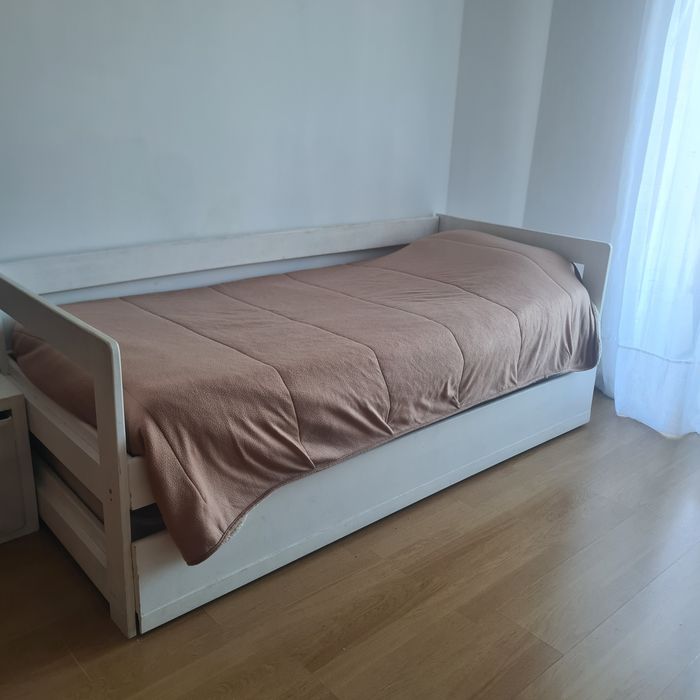 Cama de solteiro, branca, com gavetão em baixo.