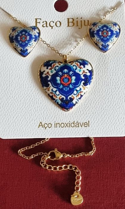 Conjunto dourado, em aço, com corações de Viana em tons de azul.