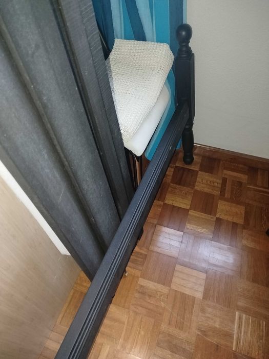 Cama de solteiro restaurada, de cor preto mate.