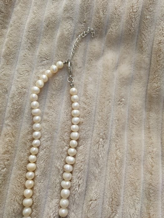 Fio de pérolas com algumas aplicações azuis escuras