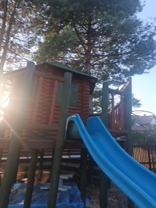 Domek dla dzieci, z zjeżdżalnią i piaskownicą.