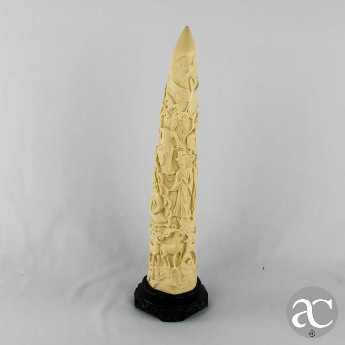 Escultura marfinite forma de dente de elefante com figuras orientais