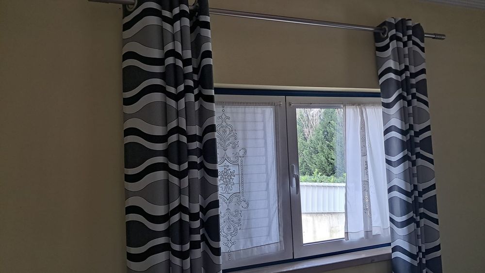 Sala com sofá, mesa de centro e cortinados