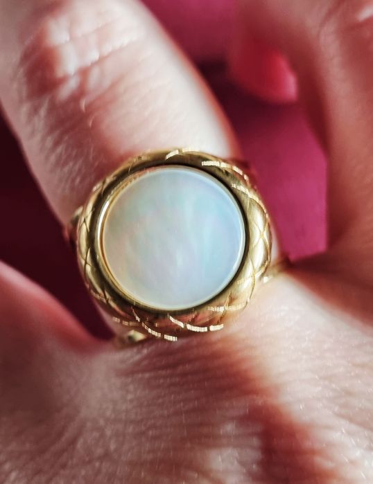 Anel dourado, em aço, com madrepérola redonda. Ajustável