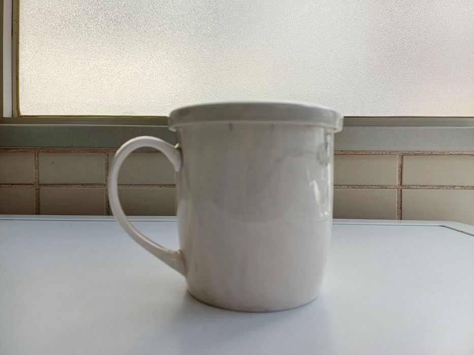Caneca de cerâmica branca com tampa e coador integrados