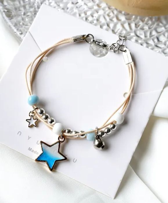 Pulseira/tornozeleira estrelas em tons de lilás, azul e rosa.