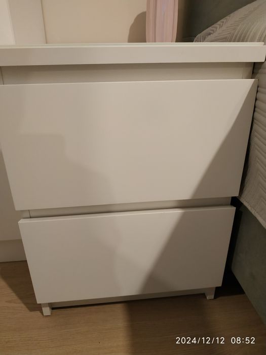 Dwie białe szafki nocne Malm wraz z białym szkłem ochronnym.
