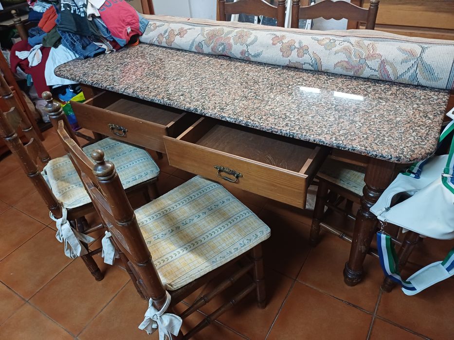 Mesa de cozinha com tampo em pedra, seis cadeiras e suas proteções
