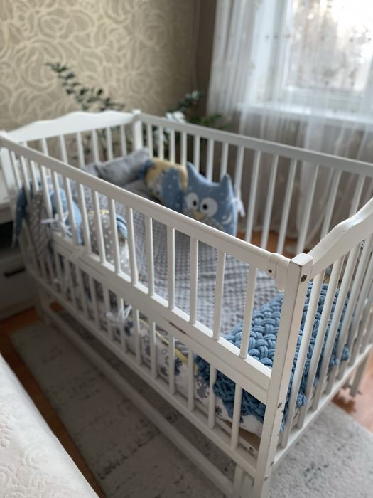 Дитяче ліжечко в білому кольорі з маятником