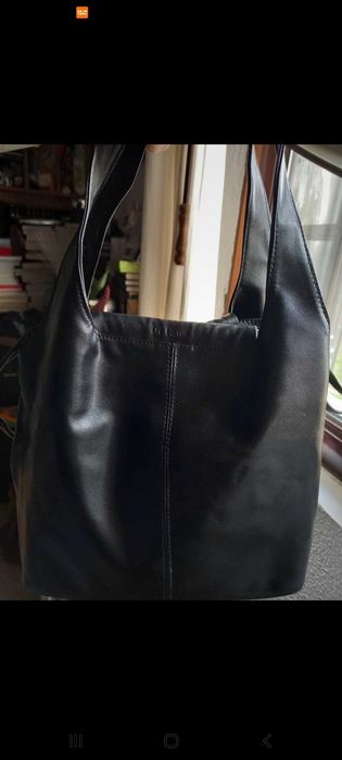 Mala preta, com mola e fios laterais para fechar.