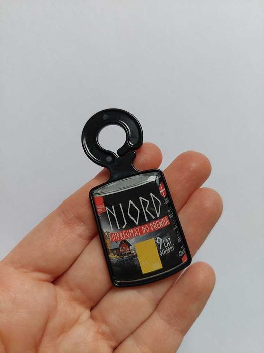 Brelok / breloczek z żetonem do wózka sklepowego w kształcie miniaturowej puszki impregnatu do drewna marki „Njord”.