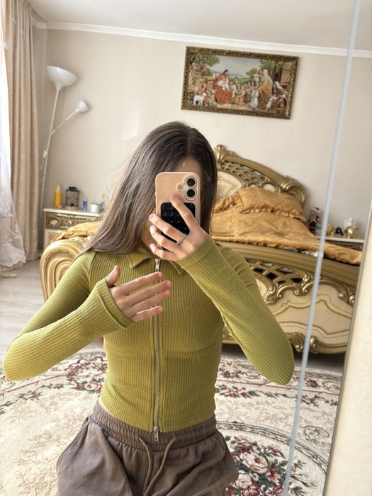зелений лонгслів у рубчик з коміром та блискавкою від бренду H&M.