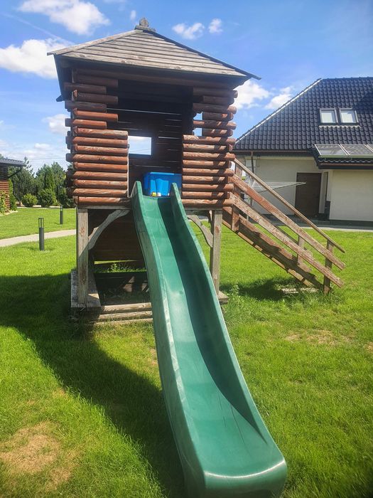 Drewniany domek ogrodowy ze zjeżdżalnią dla dzieci