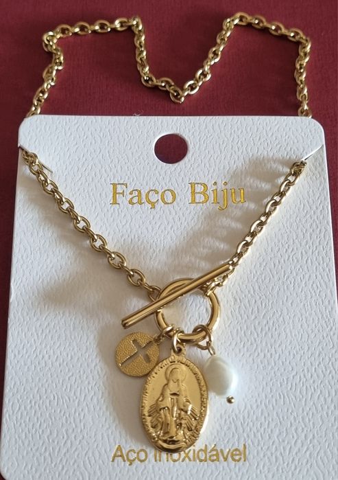 Colar dourado, em aço, com 3 pingentes diferentes. Fecho em T à frente