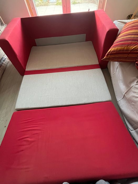 Sofá vermelho semi-novo com cama extensível