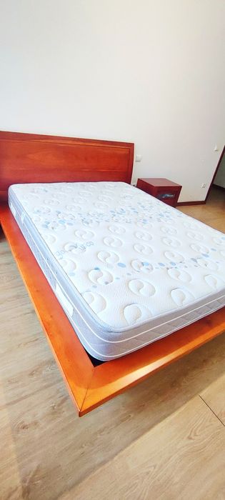 Cama casal com colchão, e mesas de cabeleireira.