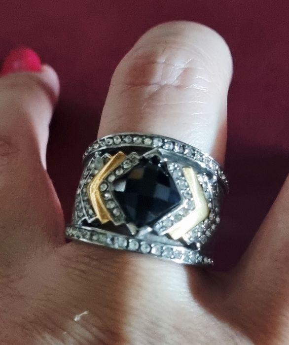 Anel prateado, em aço, com zirconias e uma pedra preta lapidada. T19