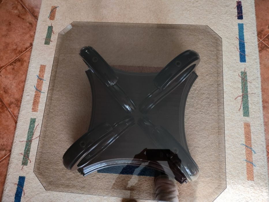 Mesa de centro centro com pés em madeira e tampo em vidro .