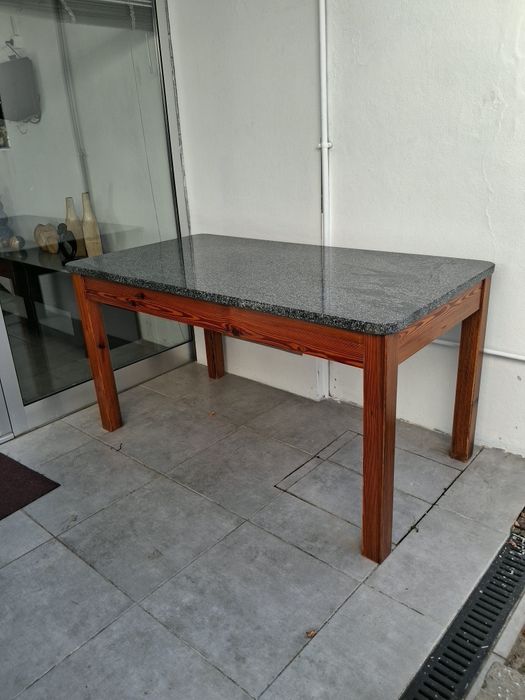 Mesa de cozinha com granito e base em madeira mogno.