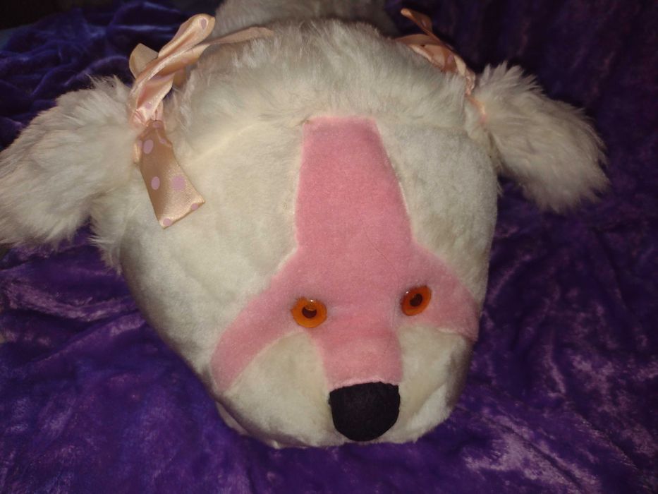 Cãozinho de peluche branco e focinho cor-de-rosa.