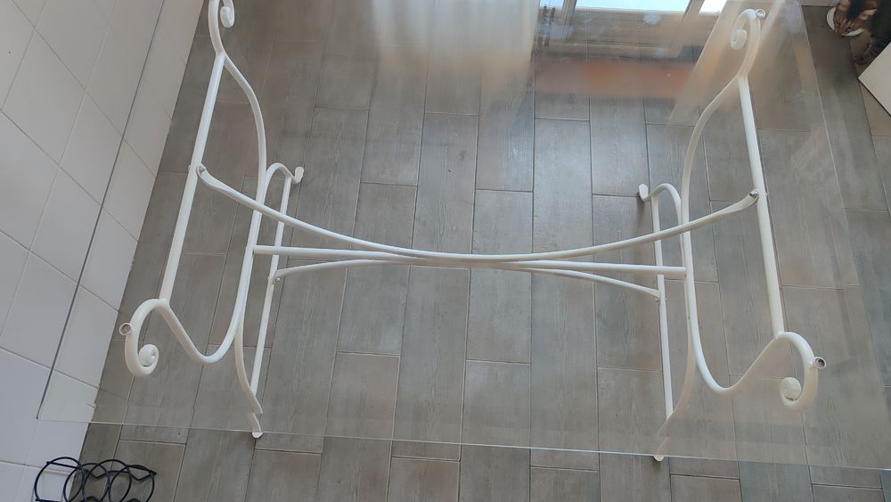 Mesa em ferro forjado com tampo de vidro.