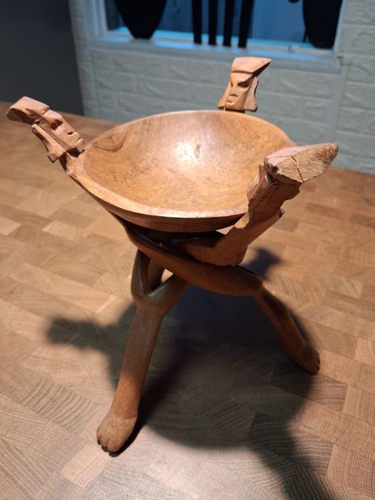 Taça de madeira com suporte de caras talhadas na madeira