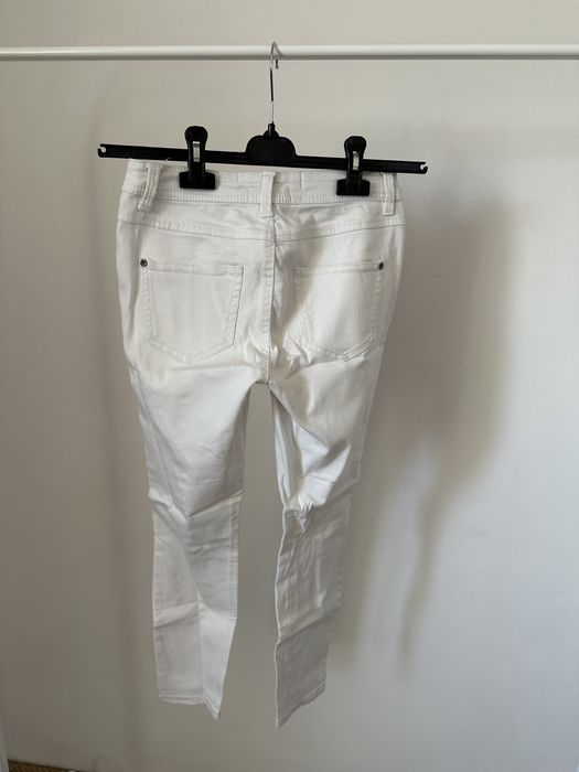 Białe spodnie z dziurami