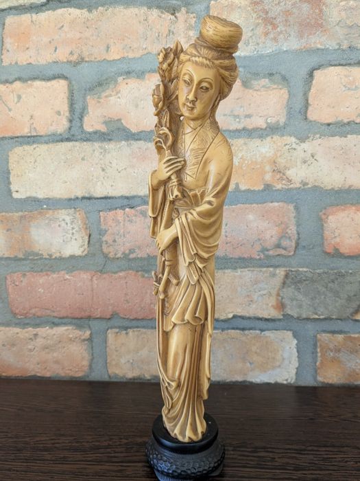 Decoração artesanal origem Ásia mulher com arranjo de flores