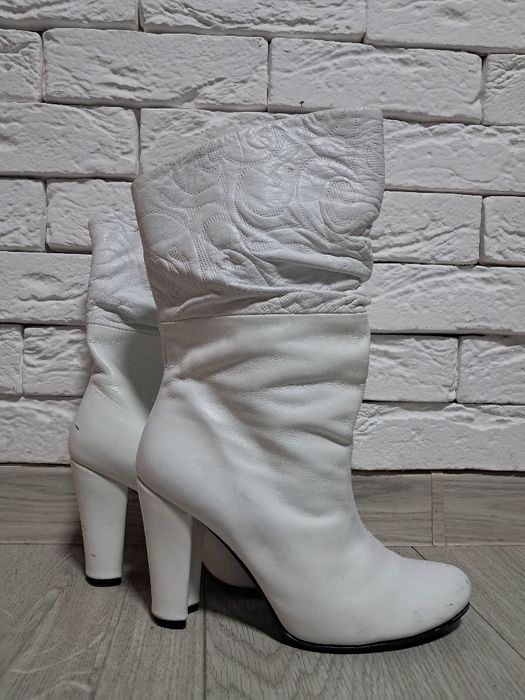 Білі жіночі чоботи на каблуку.