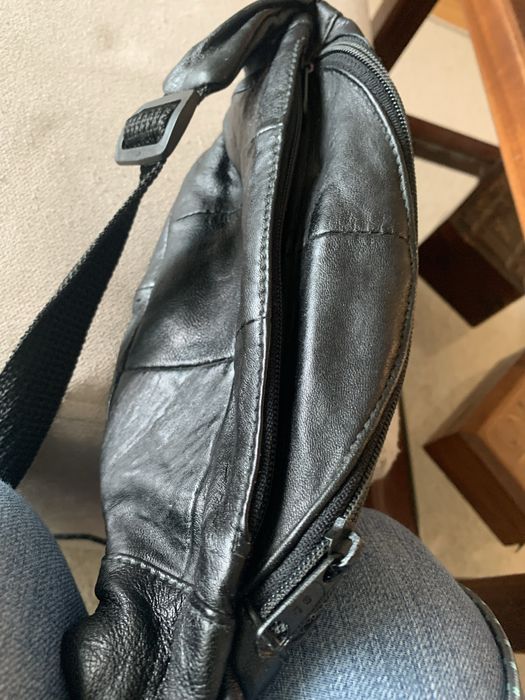 Bolsa de cabedal preta, é uma pochet classica de cintura com fecho.