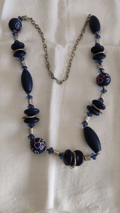 Colar  azul com desenhos em algumas contas.