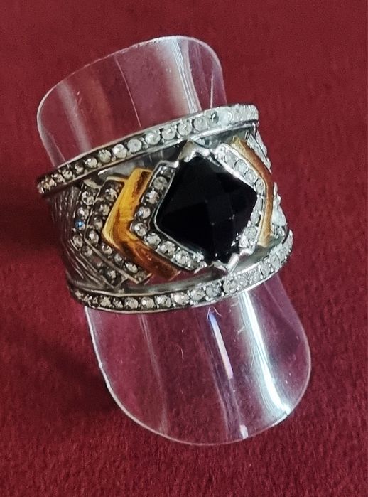 Anel prateado, em aço, com zirconias e uma pedra preta lapidada. T19