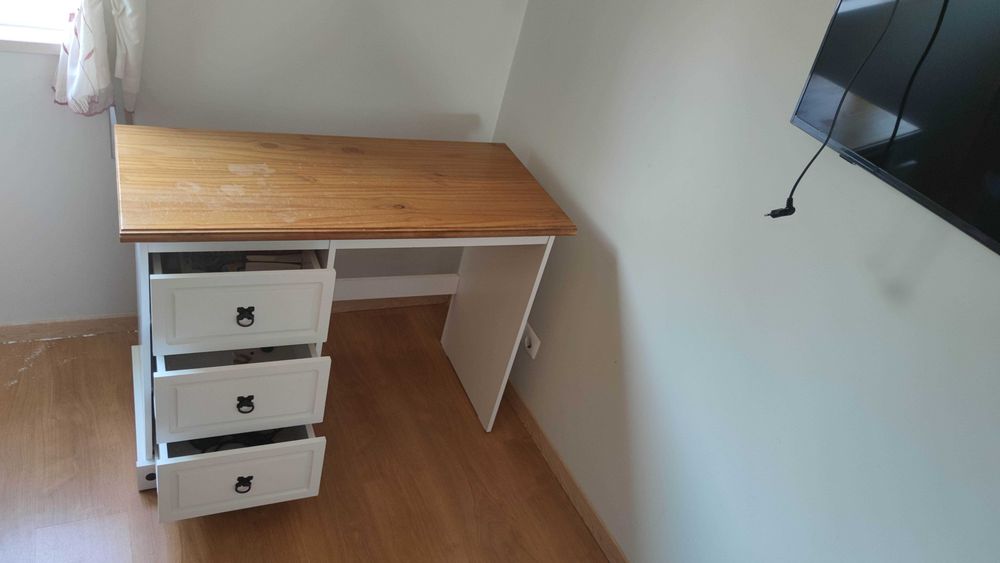 Mesa de escritório em madeira com três gavetas: comprimento de 105 cm, largura de 48 cm e altura de 80 cm.