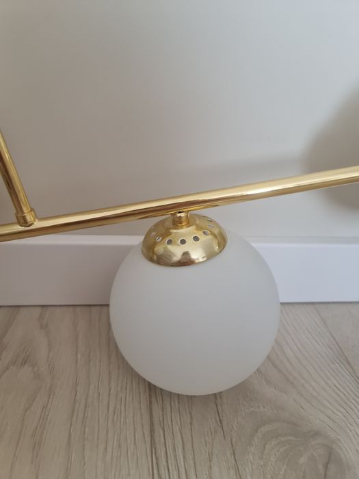 Zlota lampa sufitowa z bialymi kloszami