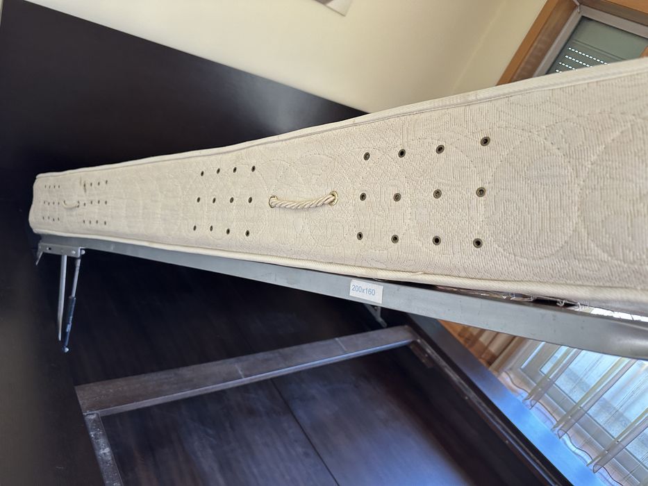 Cama casal grande com arrumação interior com blocos de apoio