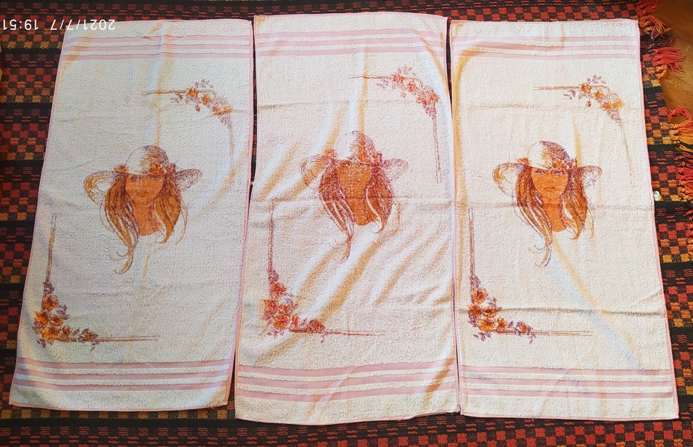 3 ręczniki różowe z twarzą dziewczynki.