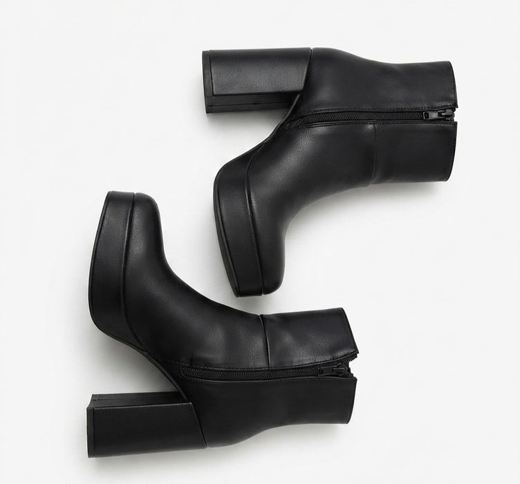 Botas pretas com plataforma e salto alto.