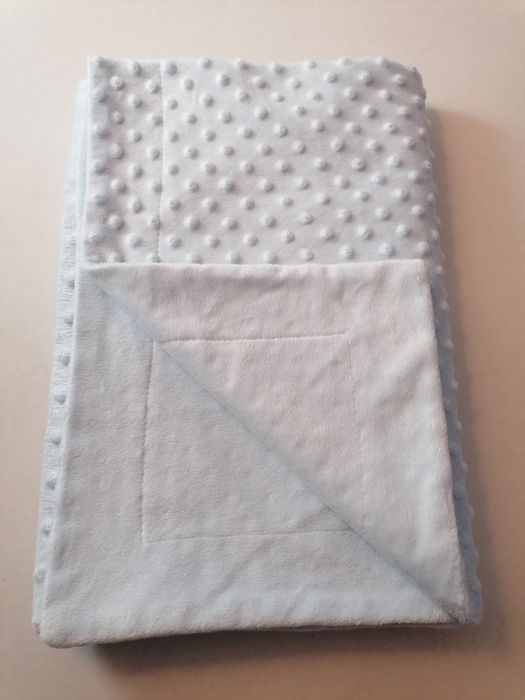 Manta azul bebé com pequenas bolinhas em relevo