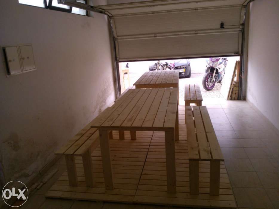 Vários conjuntos de mesas e bancos corridos.