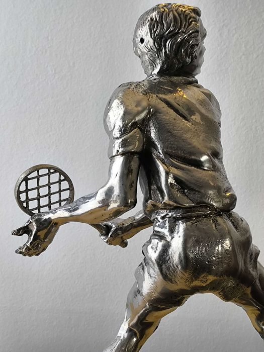 Escultura em metal prateado de jogador de ténis, com base em madeira