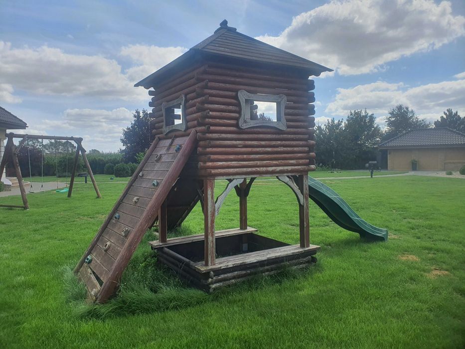 Drewniany domek ogrodowy ze zjeżdżalnią dla dzieci