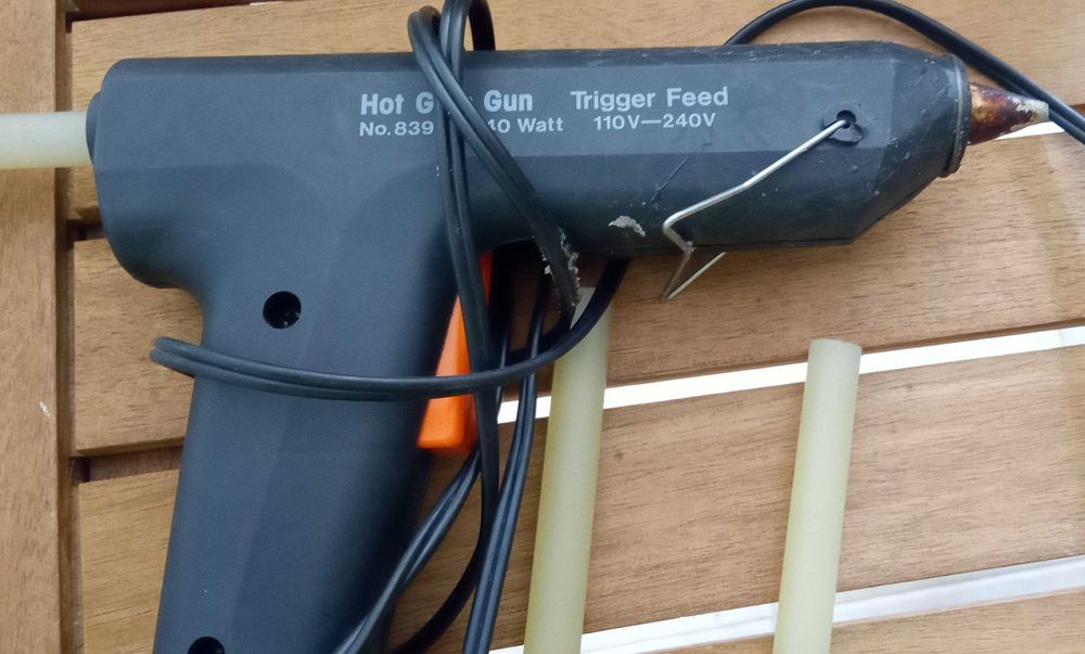 Pistola de colar a quente, com varas de cola, por 5€