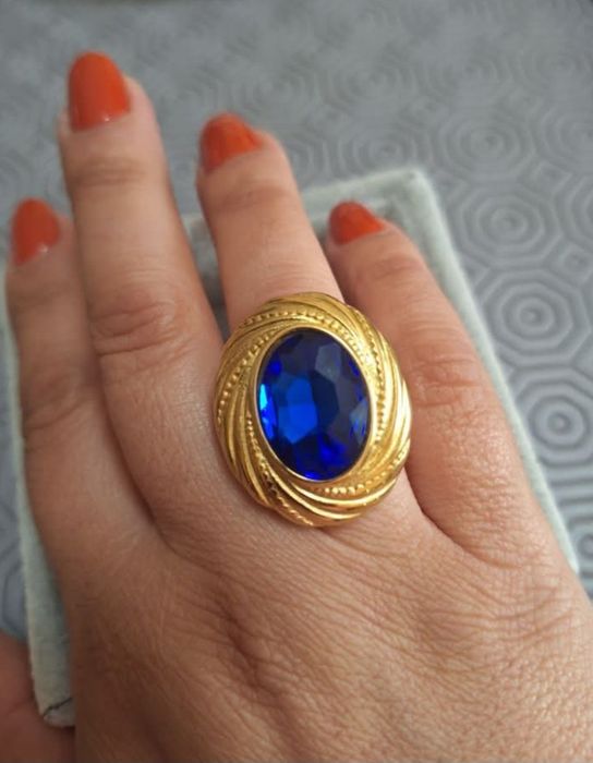 Anel dourado, em aço, com grande pedra oval azulão. T18