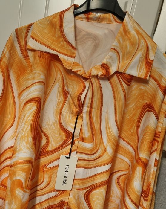 Camisa em tons laranja, tecido acetinado, mangas morcego. Oversized